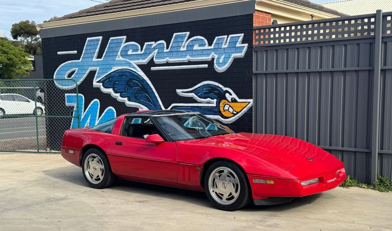 Customer's red C4 Corvette parked in front of the Henley mural